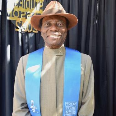 man wearing a stole and smiling